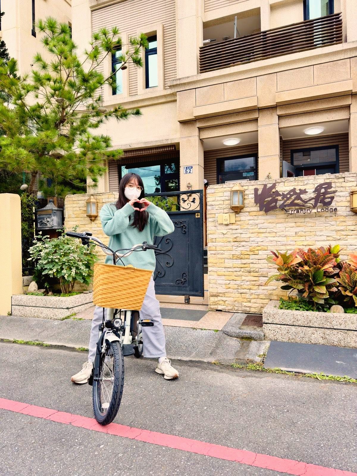 房客騎著怡然居提供的免費自行車，在門口比愛心合影