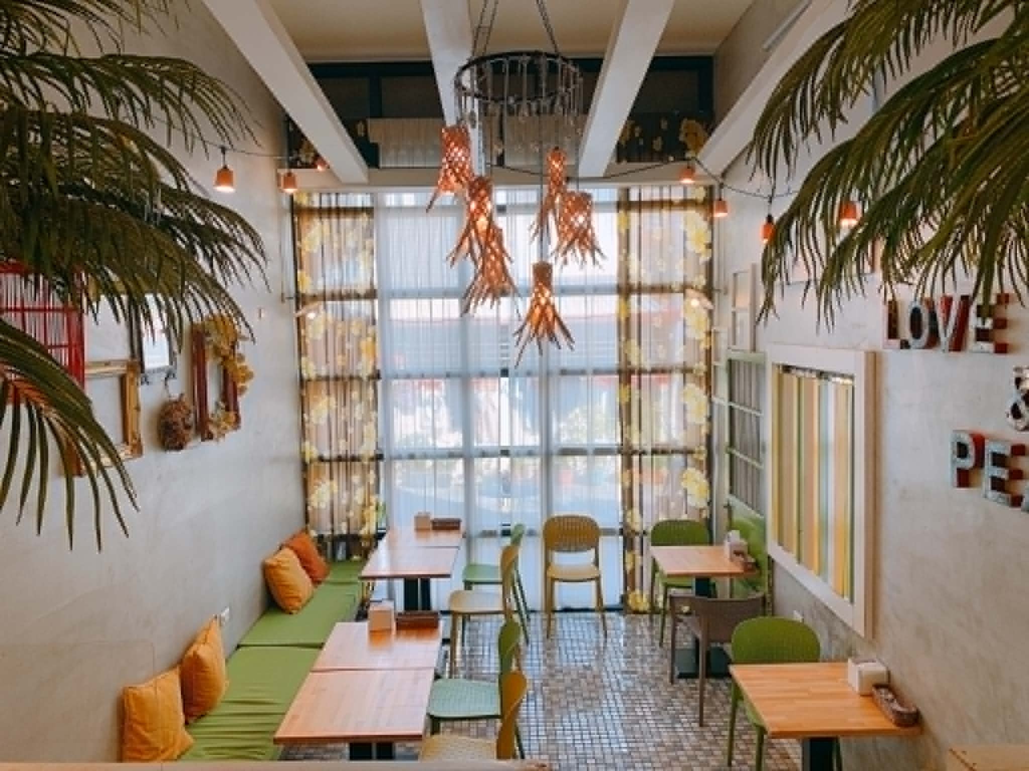 小小洋房南洋風店內用餐空間，棕櫚植栽與挑高窗景